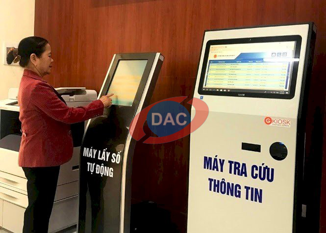 người phụ nữ đang sử dụng máy tính tra cứu thông tin Kiosk